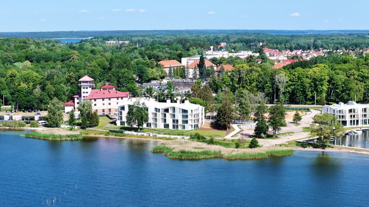 Blue lake and Gizycko city skyline and resort buildings