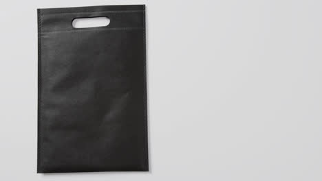 close up of black bag on white background, copy space, slow motion