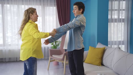 Happy-and-cheerful-mother-and-son-dancing-at-home.