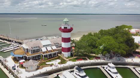 a wide drone shot of the lighthouse at harbor town on hilton head island, sc