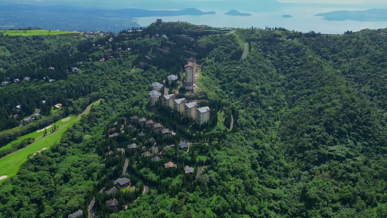A left downward pan of The Woodlands Tagaytay Highlands showing pine trees, hillside homes, and winding roads in Batangas, Philippines