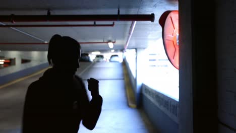 Woman-practicing-boxing-in-underground-parking-area-4k