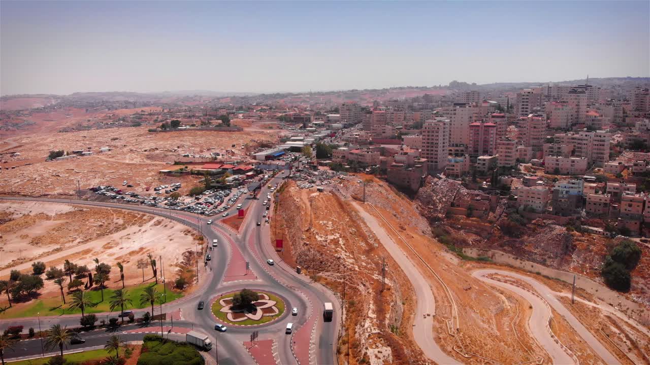 Vista aerea di una città con una rotonda e un paesaggio desertico.