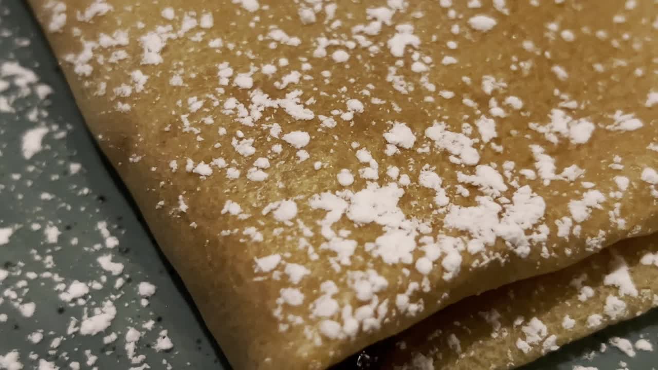 un primer plano de una crepa recién horneada, en la mano.