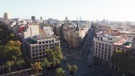 slow drone panning around the central building of plaça universitat in barcelona, showing rooftops and the urban grid