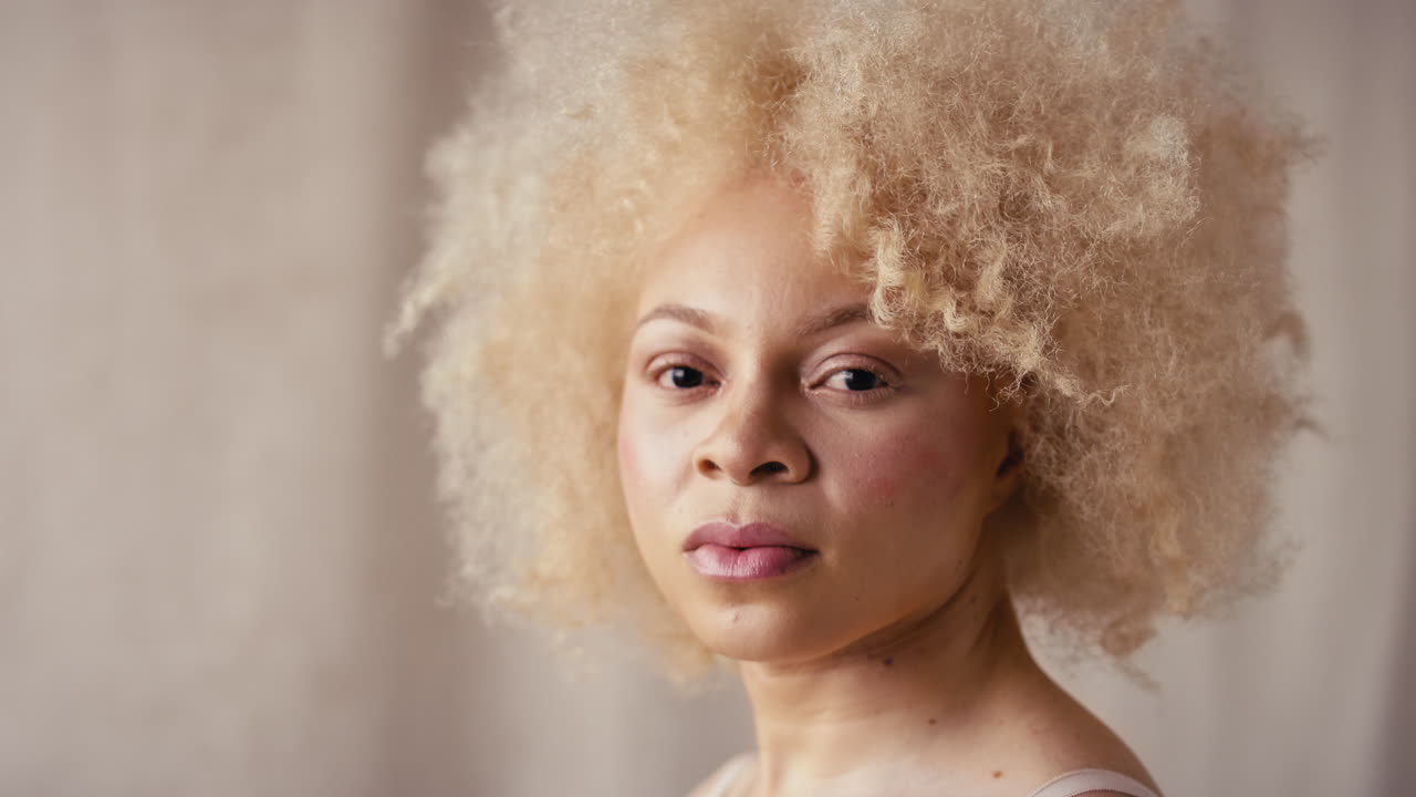 자신감 넘치는 자연스러운 알비노 여성의 스튜디오 초상화 촬영은 몸의 긍정성을 촉진하는 속옷을 입고 있습니다.