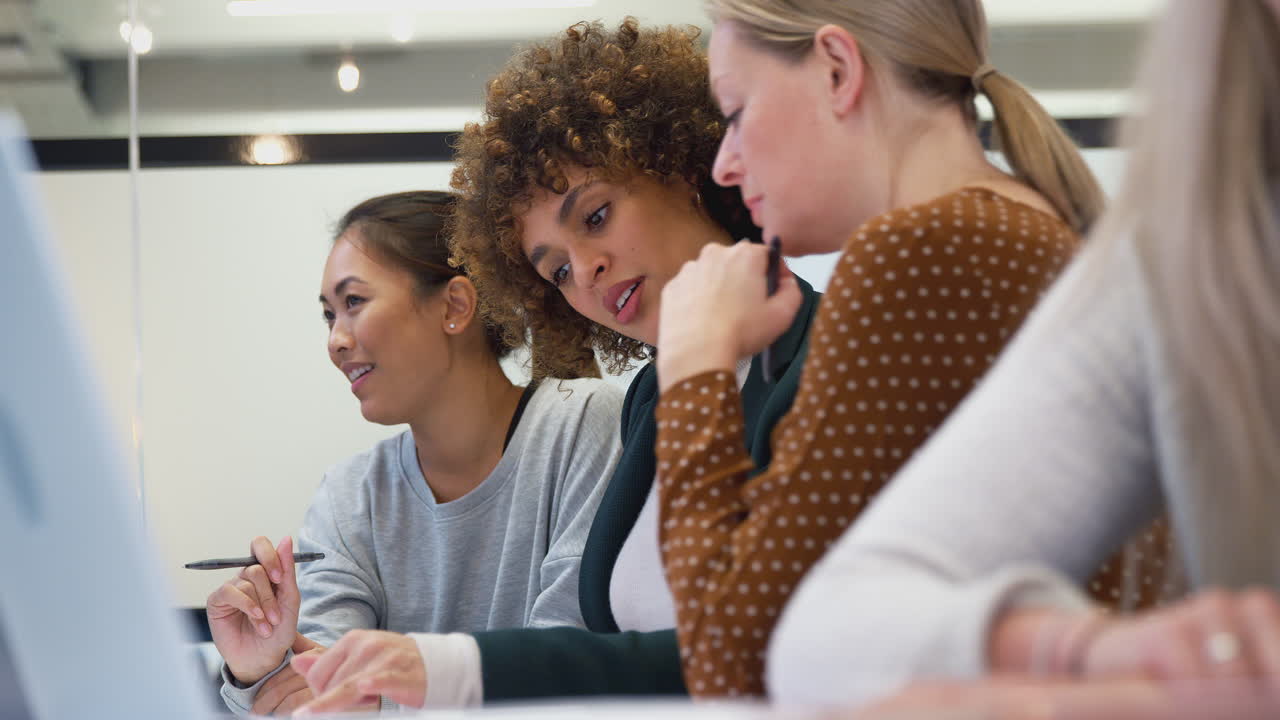 Group Of Businesswomen Collaborating In Creative Meeting Around Table In Modern Office