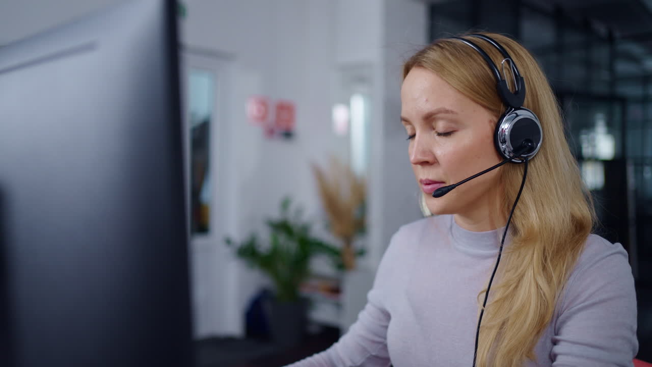 Woman working on computer with headset