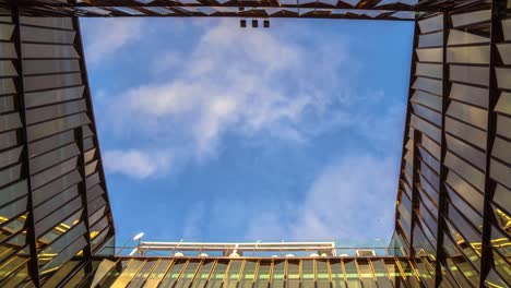 edificios de vidrio dorado con cielo azul nublado. edificios modernos de oficinas de gran altura. vista de ángulo bajo del edificio de negocios. lapso de tiempo de cielo nublado, bucle, concepto de crecimiento económico financiero.