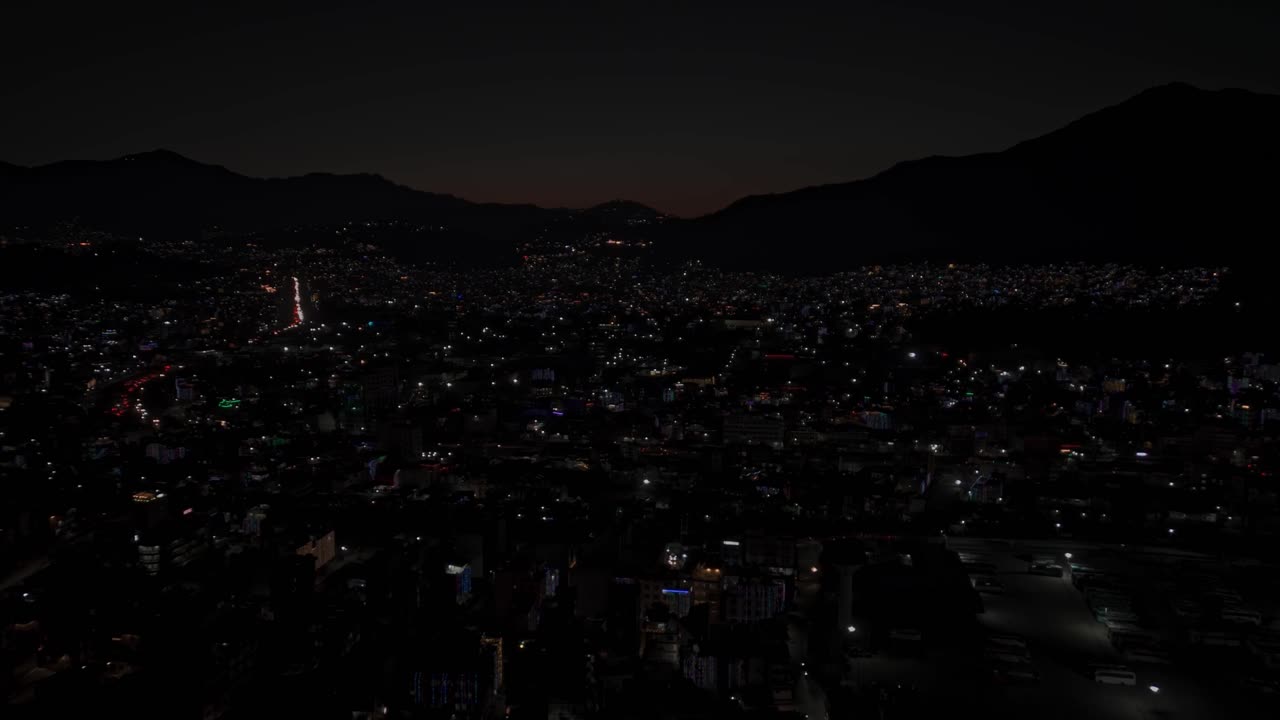 Aerial night footage of Kathmandu city during Diwali (Tihar), featuring the illuminated Dharahara Tower and glowing skyline filled with festive lights, showing Nepal’s vibrant cultural celebration