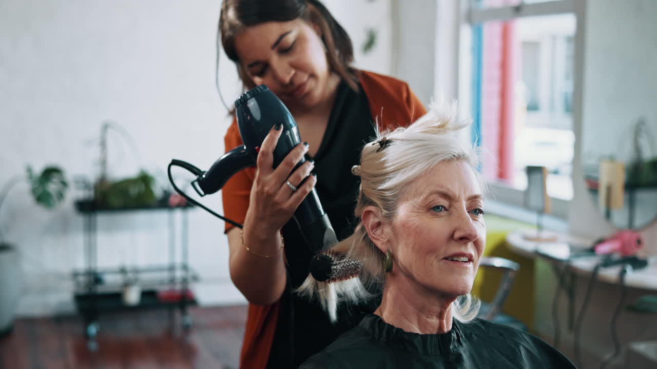 Hairdresser Blow-Drying Senior Woman's Hair in a Salon
