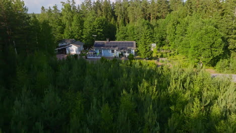 drone approaching a sunlight powered house with a ev car charging on the yard