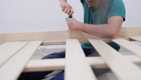 luchando por arreglar los tornillos en una cama casera hecha a medida de bricolaje