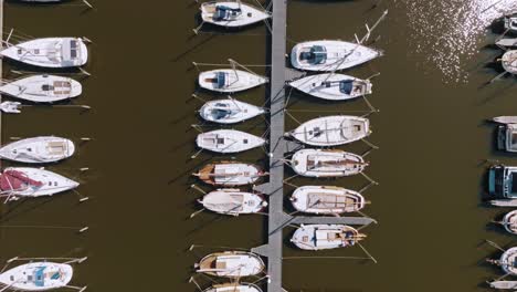 zenithal aerial shot pulling back to reveal full layout of marina with symmetrical boats