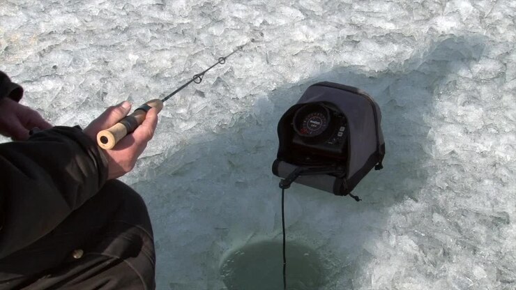 A Man Engaged in Ice Fishing on a Frozen Lake - Close Up