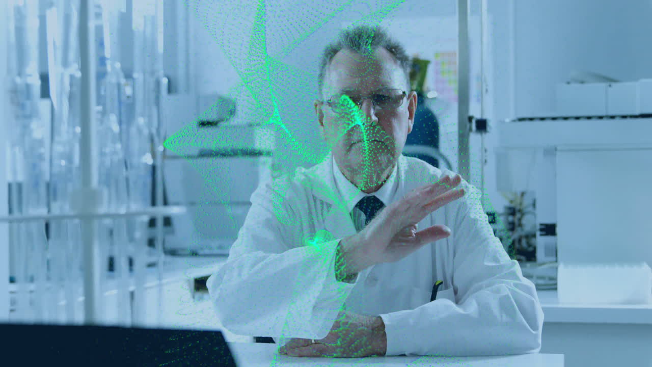 Senior male scientist gesturing toward green network above test tubes in tech lab showing data