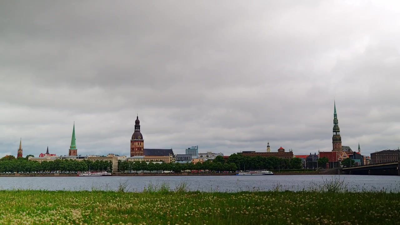 Timelapse con zoom lento dello skyline di Riga mentre nuvole di pioggia intense si muovono sopra il fiume