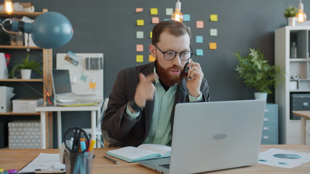 Forretningsmand i telefonopkald og med bærbar