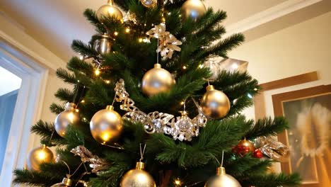 closeup of a decorated christmas tree with gold ornaments and lights