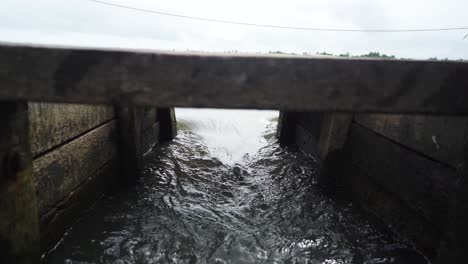 Das-Wasser-Fließt-Stark-Durch-Das-Schleusentor,-Durch-Das-Tor-Geschossen,-Wasser-Zur-Aquakulturfarm