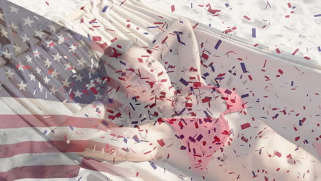 american flag waving and confetti falling against caucasian wpman laying on hammock at the beach