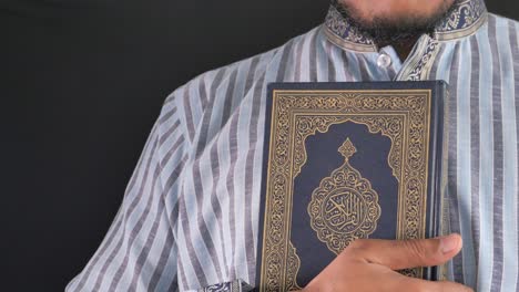 a muslim man holding the quran