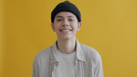 smiling young person in a plaid shirt and beanie