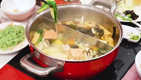 preparing and enjoying hotpot with fresh ingredients