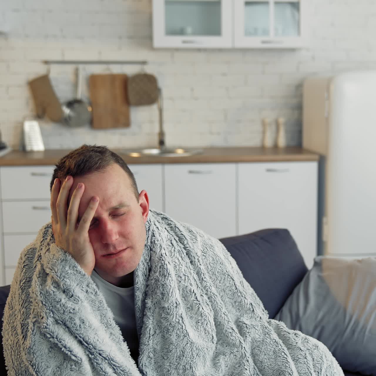 Sick young man suffering from flu at home. Pandemic. Quarantine concept