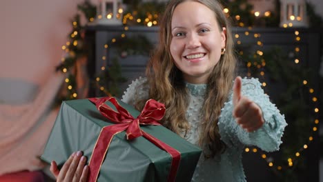 Glowing-woman-showing-thumbs-up-for-Christmas-gift,-portrait-view