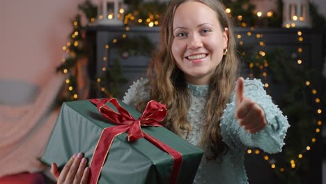 glowing woman showing thumbs up for christmas gift, portrait view