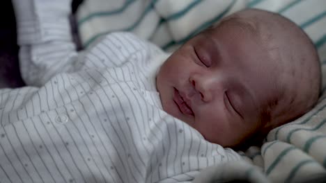 vista de cerca del bebé recién nacido musulmán con la cabeza rapada durmiendo la siesta