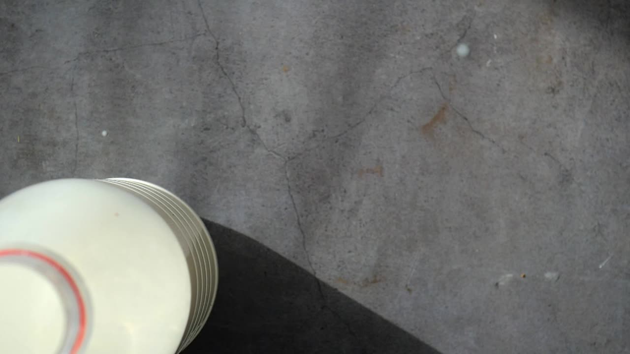 Person Holding a Glass of Milk with a Bottle