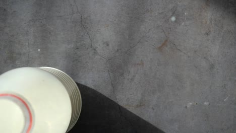 person holding a glass of milk with a bottle