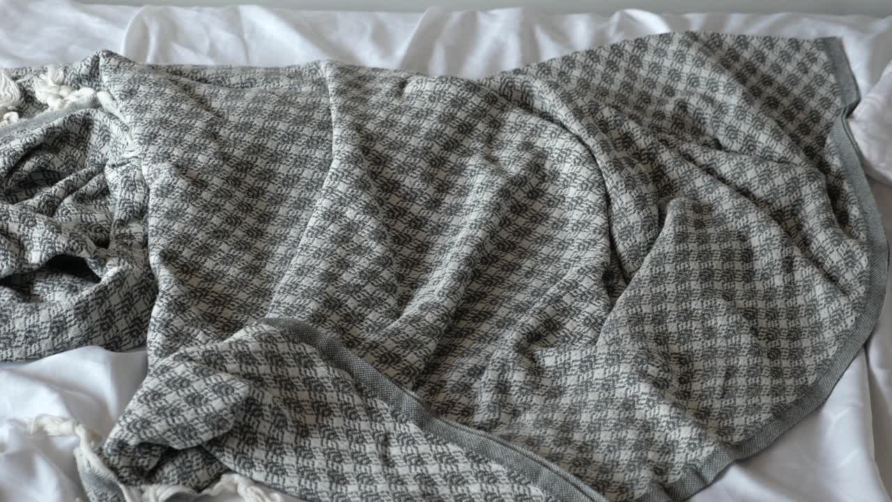 침대 위에 회색과 색의 체커드 담요