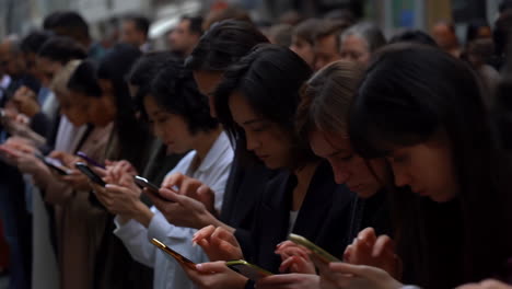 people in a crowd absorbed in their smartphones