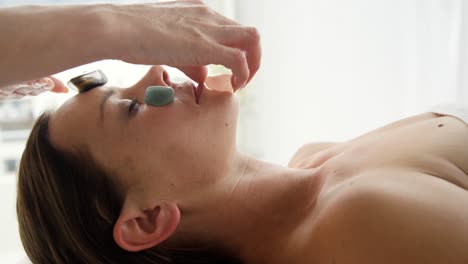 therapist putting stones on the head of her patient