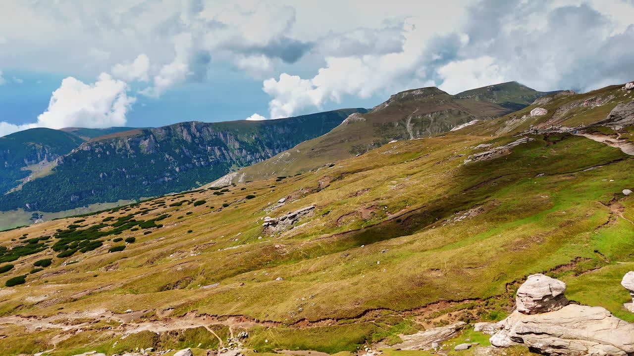 Bucegi Plateau rocks and green slopes. Panoramic view of Bucegi Plateau with eroded rocks and green hills