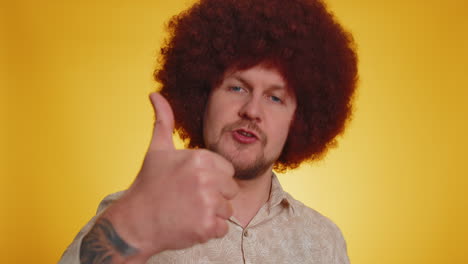 tourist man with afro hairstyle showing thumbs up and nodding in approval, successful good work