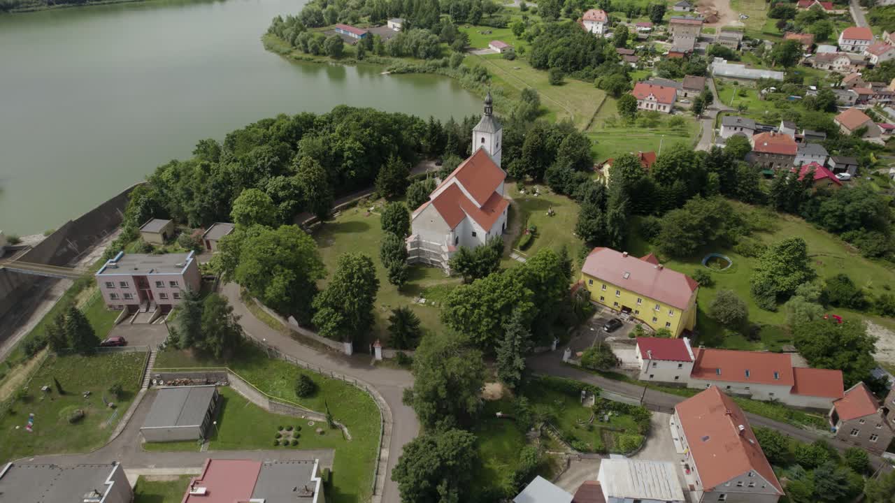 órbita aérea más amplia sobre la ciudad de dobromierz y una antigua iglesia situada en la colina sobre el depósito de agua contra inundaciones