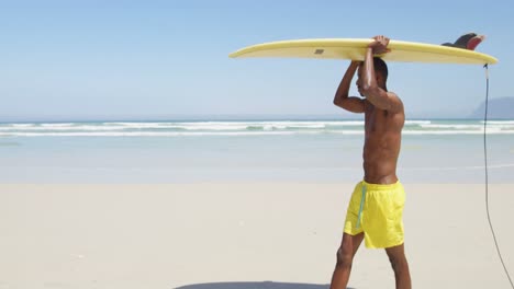 surfista masculino llevando una tabla de surf en su cabeza en la playa 4k