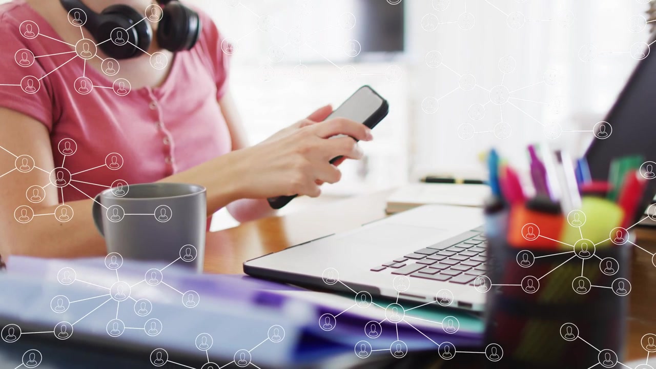 Donna adulta che tocca il telefono, afferra il mouse, digita sul laptop, con l'interfaccia utente di rete che mostra dati aziendali.