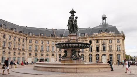 people walking around historic fountain place de la bourse in bordeaux