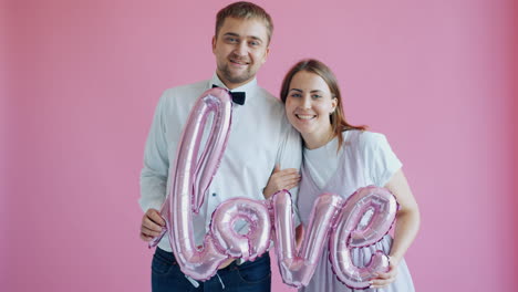 couple holding love balloons