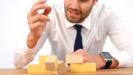 businessman playing with building blocks