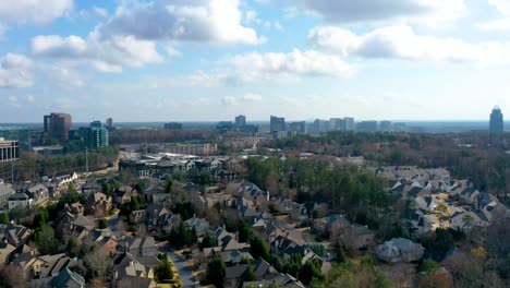 timelapse aéreo de drones mirando hacia el centro de atlanta, georgia desde arriba de los vecindarios de sandy springs mientras las nubes pasan creando sombras sobre las casas