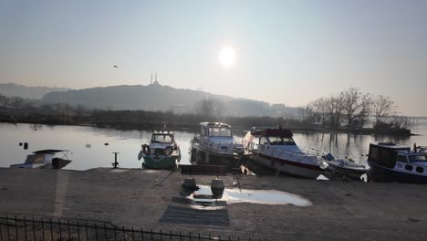 sunrise over a turkish river with docked boats