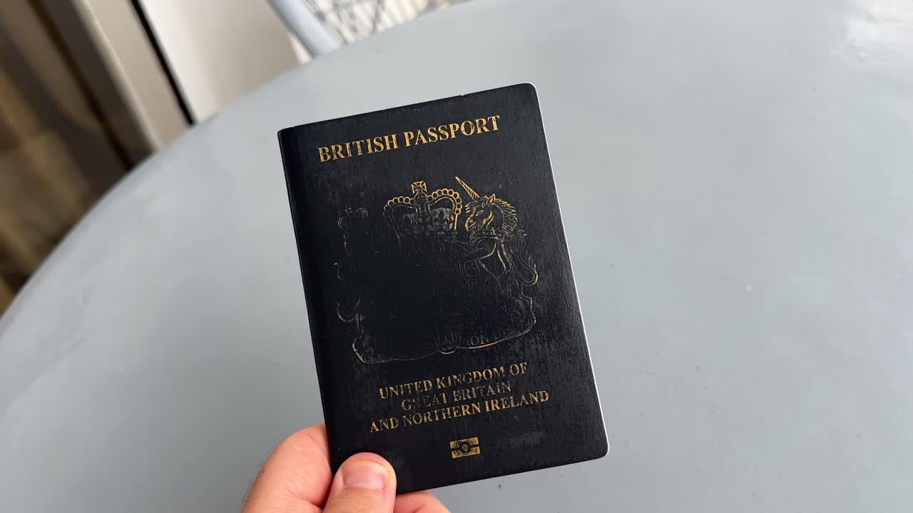 POV close up of a man holding a British passport worn bad condition travel identification document UK