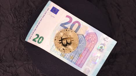 bitcoin coin on top of 20 euro note. - high angle shot