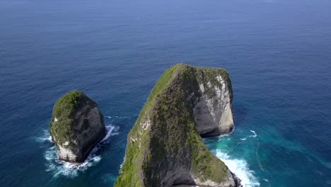 Espectacular-Vista-Aérea-Círculo-De-Vuelo-Disparo-De-Drone-De-Isla-Mágica-Mística-En-El-Océano-Playa-Kelingking-En-Nusa-Penida-En-Bali-Indonesia-Es-Parque-Jurásico-Naturaleza-Cinematográfica-Vista-Del-Acantilado-Arriba-Por-Philipp-Marnitz